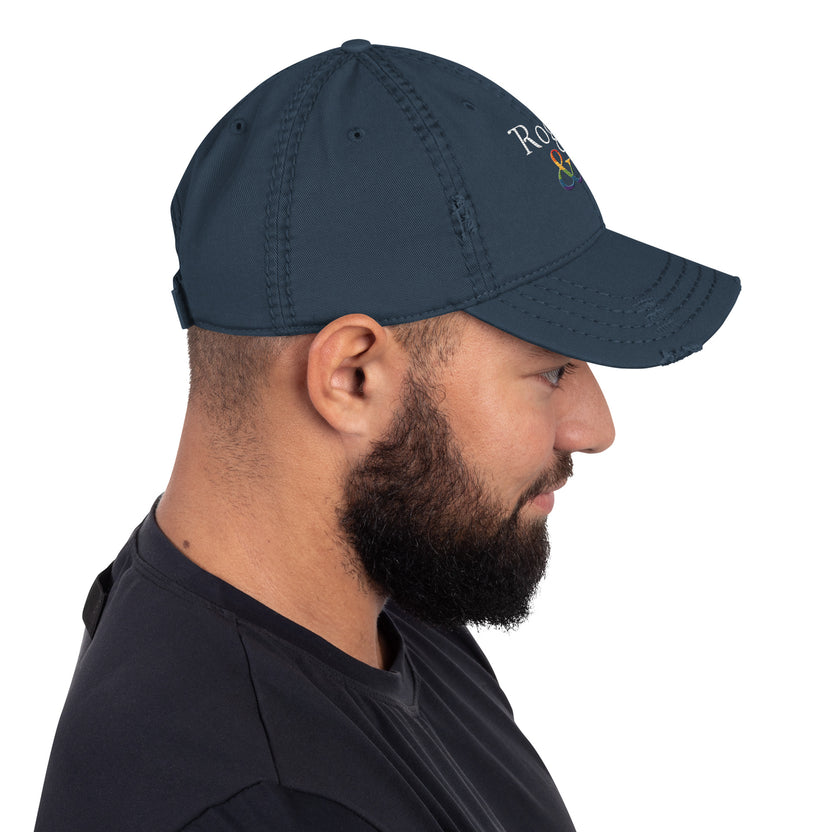 and well-worn pride cap, distressed pride hat, inclusive embroidered hat, rogue and rye lgbtq gear, queer and proud cap, lived-in pride cap, soft cotton twill hat, outright international donation, evolving identity hat, rogue and rye pride collection, gender inclusive pride wear, adjustable distressed cap, embroidered and message, everyday queer pride gear, unstructured pride cap, pride fashion hat, lgbtq supportive cap