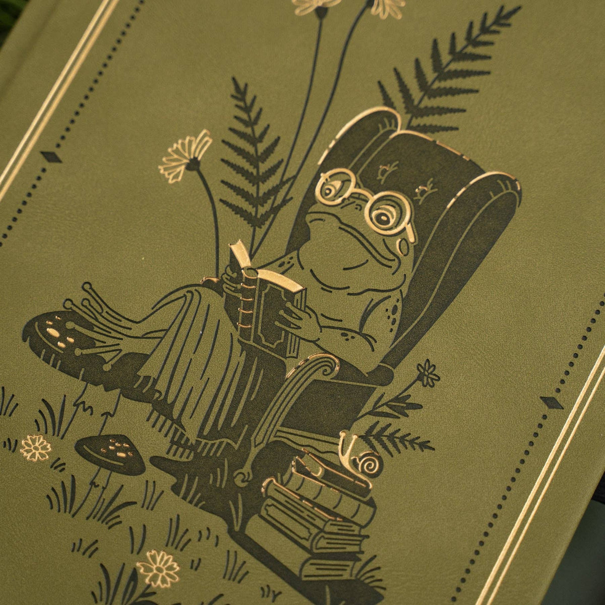 Close-up of frog reading in an armchair on Literary Frog notebook cover