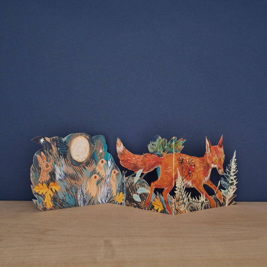 Mark Hearld Three Fold Fox accordion greeting card opened to display a moonlit woodland scene with a fox, woodland birds, and a full moon.