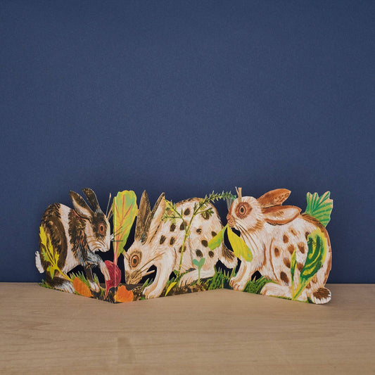 Mark Hearld Three Fold Rabbits accordion greeting card featuring illustrated rabbits exploring among woodland leaves, roots, and wild foliage.