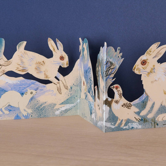 Mark Hearld Winter Wildlife accordion greeting card featuring illustrated hares, ptarmigan, and a stoat in a snowy winter landscape.