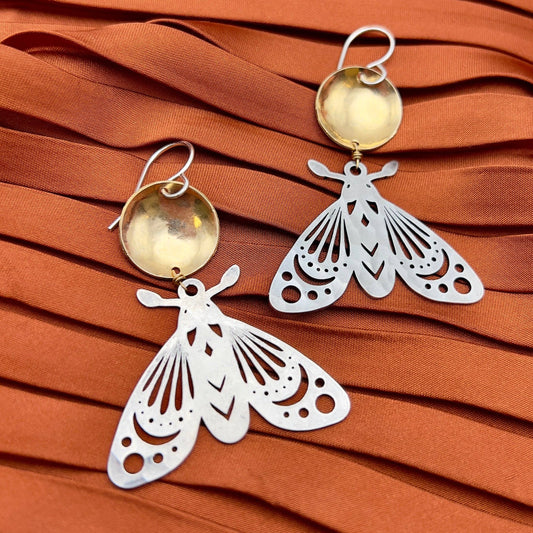 gold silver moth earrings, mixed metal moth jewelry, gold over silver earrings, celestial moth earrings, forest-inspired jewelry, brass and silver moth earrings, artisan moth earrings, hypoallergenic gold filled earrings, sterling silver moth jewelry, moonlight inspired earrings, fantasy woodland earrings, handcrafted insect earrings, dnd forest fae jewelry, nature inspired statement earrings, moth earrings for sensitive ears