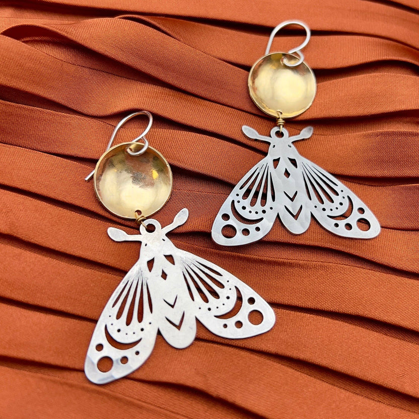 gold silver moth earrings, mixed metal moth jewelry, gold over silver earrings, celestial moth earrings, forest-inspired jewelry, brass and silver moth earrings, artisan moth earrings, hypoallergenic gold filled earrings, sterling silver moth jewelry, moonlight inspired earrings, fantasy woodland earrings, handcrafted insect earrings, dnd forest fae jewelry, nature inspired statement earrings, moth earrings for sensitive ears