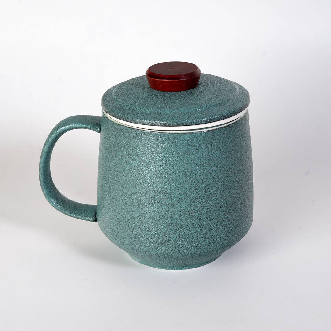 green mountain tea mug, porcelain tea mug with infuser, Urban Tokyo tea mug green, Japanese-style tea brewing mug, loose leaf tea porcelain cup, lidded infuser mug, minimalist green tea mug, modern Japanese home goods, gift for tea drinkers, mountain design mug, cozy kitchen gifts, ceramic tea mug with lid, Rogue & Rye cozy rituals collection, elegant tea accessories, woman-owned brand gift ideas.