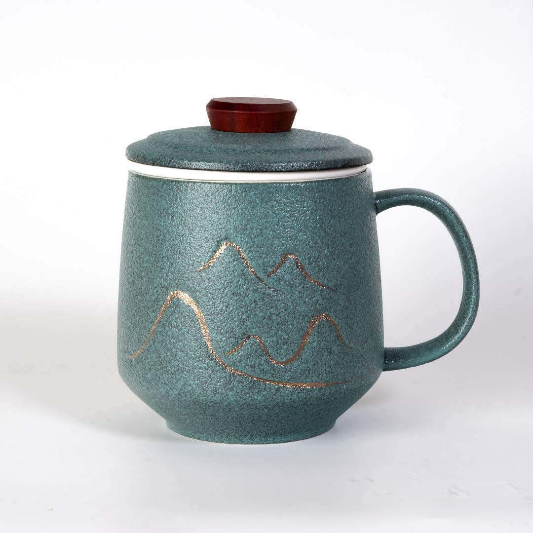 green mountain tea mug, porcelain tea mug with infuser, Urban Tokyo tea mug green, Japanese-style tea brewing mug, loose leaf tea porcelain cup, lidded infuser mug, minimalist green tea mug, modern Japanese home goods, gift for tea drinkers, mountain design mug, cozy kitchen gifts, ceramic tea mug with lid, Rogue & Rye cozy rituals collection, elegant tea accessories, woman-owned brand gift ideas.