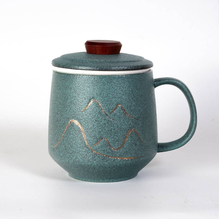 green mountain tea mug, porcelain tea mug with infuser, Urban Tokyo tea mug green, Japanese-style tea brewing mug, loose leaf tea porcelain cup, lidded infuser mug, minimalist green tea mug, modern Japanese home goods, gift for tea drinkers, mountain design mug, cozy kitchen gifts, ceramic tea mug with lid, Rogue & Rye cozy rituals collection, elegant tea accessories, woman-owned brand gift ideas.