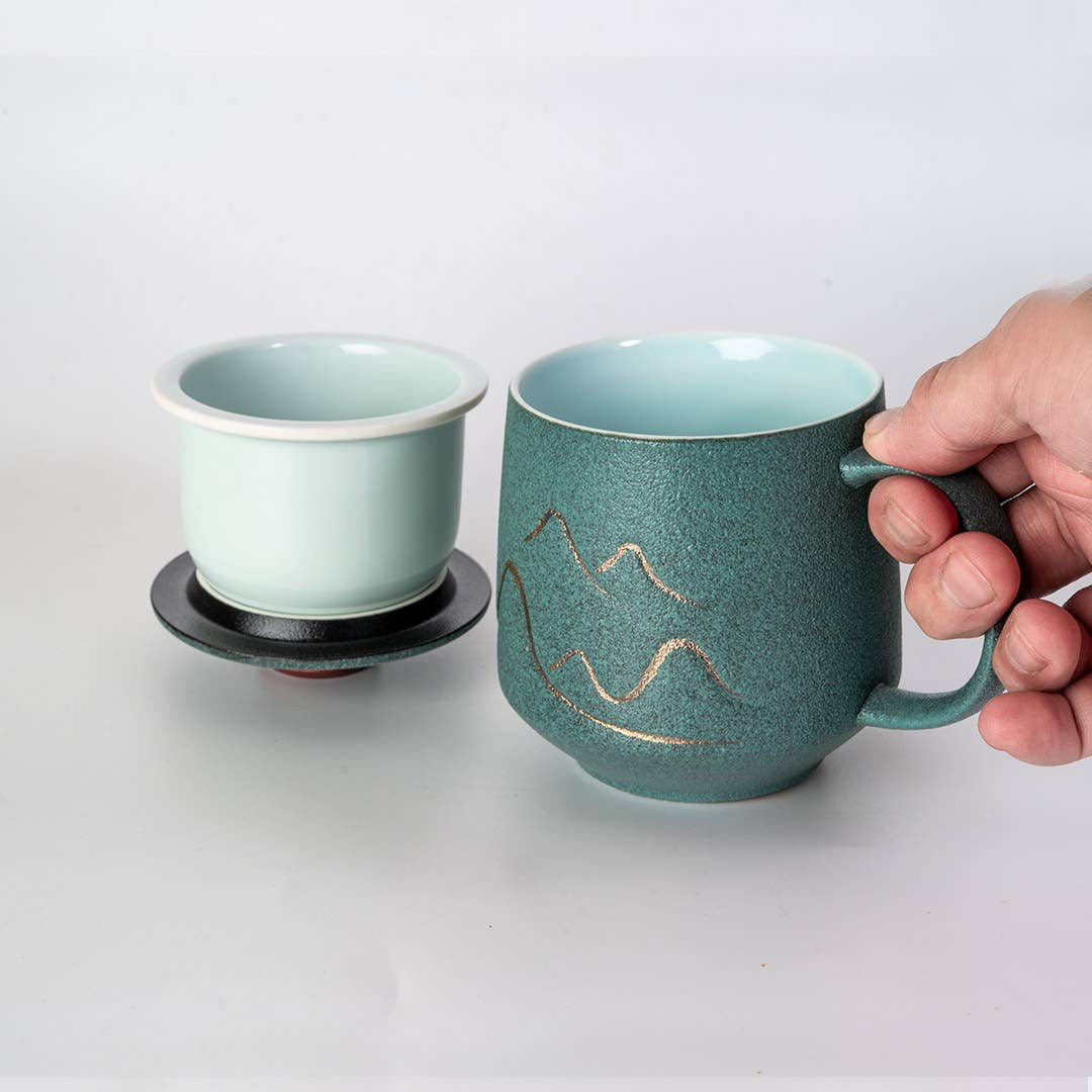 green mountain tea mug, porcelain tea mug with infuser, Urban Tokyo tea mug green, Japanese-style tea brewing mug, loose leaf tea porcelain cup, lidded infuser mug, minimalist green tea mug, modern Japanese home goods, gift for tea drinkers, mountain design mug, cozy kitchen gifts, ceramic tea mug with lid, Rogue & Rye cozy rituals collection, elegant tea accessories, woman-owned brand gift ideas.