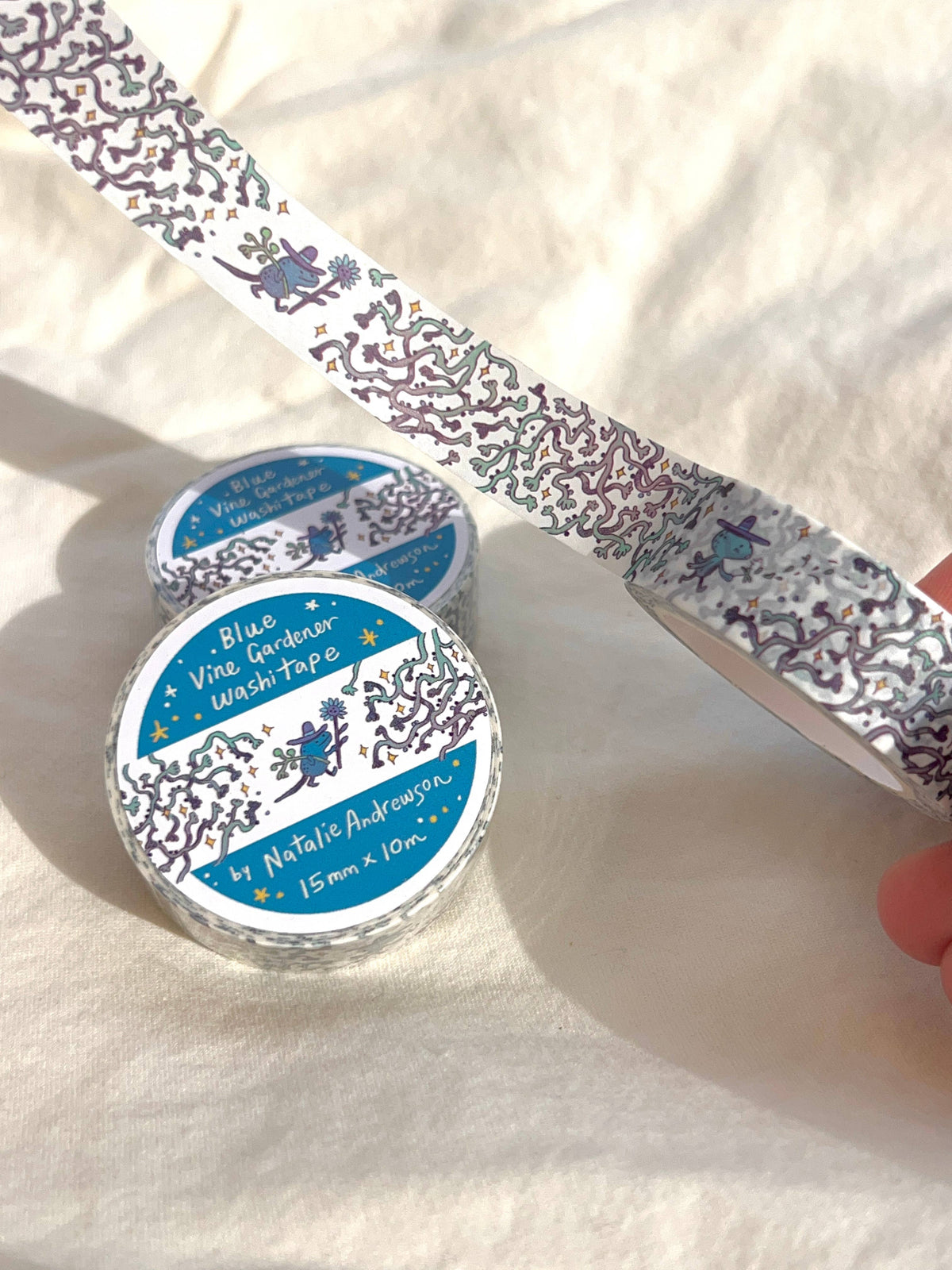 Blue Vine Collector washi tape roll with illustrated blue gardeners and winding vines