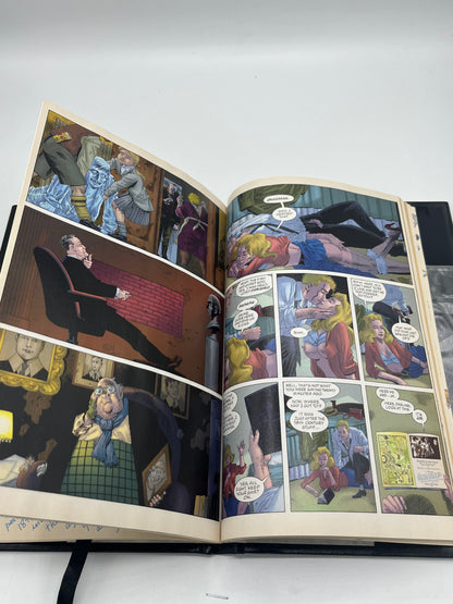 Preowned Like New hardcover edition of The League of Extraordinary Gentlemen: The Black Dossier by Alan Moore and Kevin O’Neill. This premium-format graphic novel is known for its inventive “dossier” presentation and collectible design, including a 3-D section in many editions. A great pick for fans of literary mashups, steampunk/alt-history comics, and high-design graphic novel hardcovers.