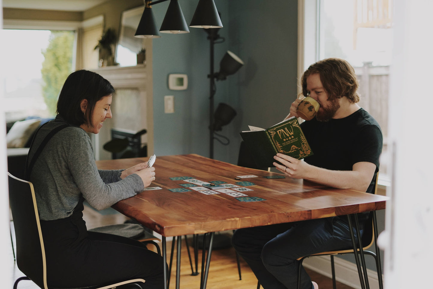 pnw card games book, pacific northwest inspired games, megan wyreweden art, thomas cardwell game designer, nature themed card games, foraging card games, orca salmon mushroom games, coastal forest games, pacific northwest game night, illustrated card game book, camping games with deck of cards, solo and group card games, pnw camping activities, original card games book, pacific northwest gifts, travel