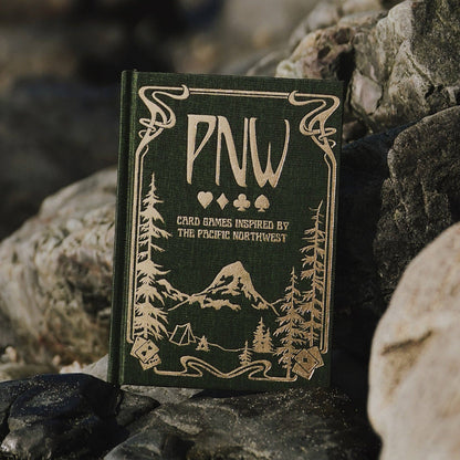 pnw card games book, pacific northwest inspired games, megan wyreweden art, thomas cardwell game designer, nature themed card games, foraging card games, orca salmon mushroom games, coastal forest games, pacific northwest game night, illustrated card game book, camping games with deck of cards, solo and group card games, pnw camping activities, original card games book, pacific northwest gifts, travel