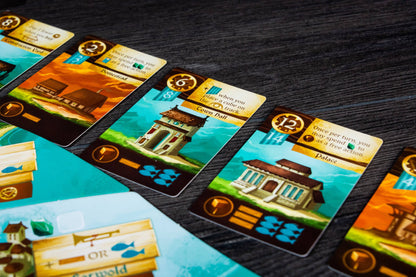 Islebound Emerald Edition, Islebound board game, Red Raven Games Islebound, World of Arzium board game, Ryan Laukat game, sea faring strategy board game, nautical fantasy board game, archipelago board game, pirates and sea monsters board game, trade build invade board game, island town strategy game, capital city building board game, crew hiring board game, emerald resource board game, revised building deck Emerald Edition, 2 to 4 player strategy game, 30 minute strategy board game, fantasy adventure strate