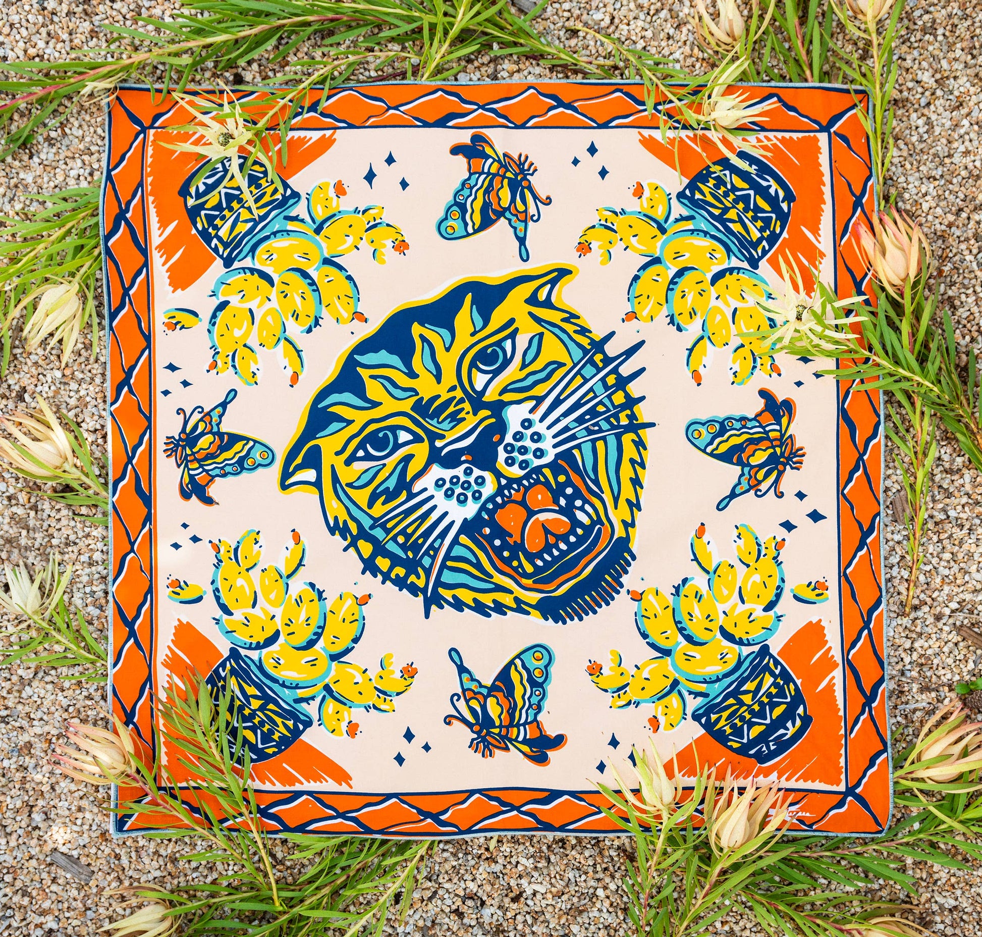 The Desert Sun Bandana by Bandits Bandanas features original artwork by Michael Matheson (Metal Teepee) and is made from Fair Trade Certified, 100% organic cotton. Soft, breathable, and versatile, this 21" × 21" bandana is perfect for hair, neck, or bag styling. Each purchase gives back, with 10% of proceeds supporting the International Rescue Committee, making it a meaningful, artist-driven accessory designed to be lived in.