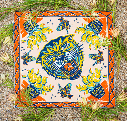 The Desert Sun Bandana by Bandits Bandanas features original artwork by Michael Matheson (Metal Teepee) and is made from Fair Trade Certified, 100% organic cotton. Soft, breathable, and versatile, this 21" × 21" bandana is perfect for hair, neck, or bag styling. Each purchase gives back, with 10% of proceeds supporting the International Rescue Committee, making it a meaningful, artist-driven accessory designed to be lived in.