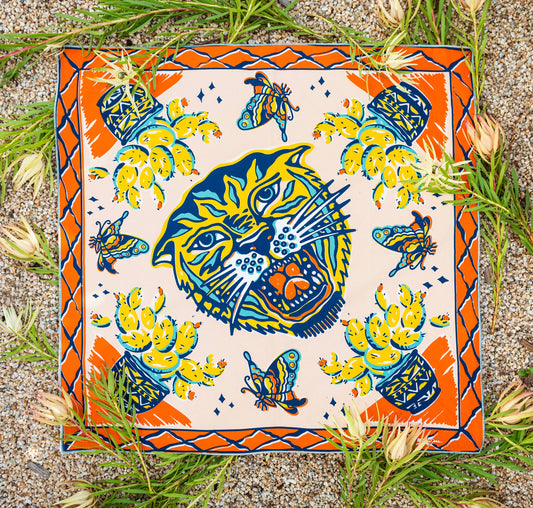 The Desert Sun Bandana by Bandits Bandanas features original artwork by Michael Matheson (Metal Teepee) and is made from Fair Trade Certified, 100% organic cotton. Soft, breathable, and versatile, this 21" × 21" bandana is perfect for hair, neck, or bag styling. Each purchase gives back, with 10% of proceeds supporting the International Rescue Committee, making it a meaningful, artist-driven accessory designed to be lived in.
