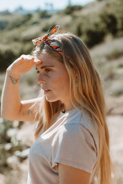 The Desert Sun Bandana by Bandits Bandanas features original artwork by Michael Matheson (Metal Teepee) and is made from Fair Trade Certified, 100% organic cotton. Soft, breathable, and versatile, this 21" × 21" bandana is perfect for hair, neck, or bag styling. Each purchase gives back, with 10% of proceeds supporting the International Rescue Committee, making it a meaningful, artist-driven accessory designed to be lived in.