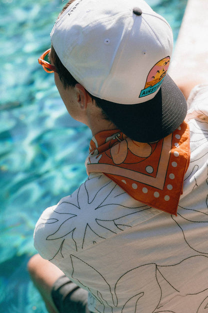 The Na’Pali Coast Bandana by Bandits Bandanas features original artwork by Lisa McCormick, inspired by the iconic coastline of Kaua‘i. Made from 100% GOTS-certified organic cotton and Fair Trade Certified, this ultra-soft bandana is a versatile accessory for hair, neck, bag styling, and everyday wear. Plus, 10% of proceeds support Love One International, making it a thoughtful, artist-driven gift with real impact.