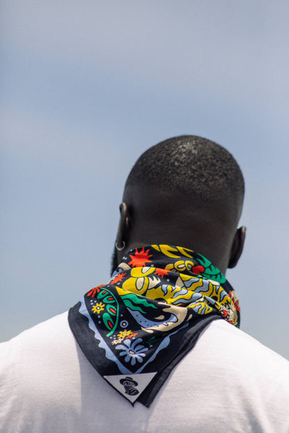 The Tropic Like It’s Hot Bandana by Bandits Bandanas features original artwork by Joshua Noom and is crafted from GOTS-certified, Fair Trade Certified organic cotton. Soft, breathable, and easy to style, this 21" × 21" bandana is perfect for everyday wear—at the neck, in the hair, or tied to a favorite bag. Each purchase gives back, with 10% of proceeds supporting American Red Cross Hurricane Relief, making it a vibrant, artist-driven accessory with meaningful impact.