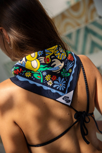 The Tropic Like It’s Hot Bandana by Bandits Bandanas features original artwork by Joshua Noom and is crafted from GOTS-certified, Fair Trade Certified organic cotton. Soft, breathable, and easy to style, this 21" × 21" bandana is perfect for everyday wear—at the neck, in the hair, or tied to a favorite bag. Each purchase gives back, with 10% of proceeds supporting American Red Cross Hurricane Relief, making it a vibrant, artist-driven accessory with meaningful impact.