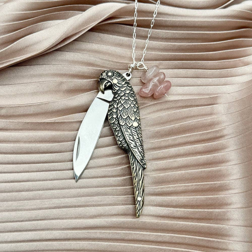 The Polly Necklace by Fluff Hardware is a handcrafted sterling silver necklace featuring a parrot-inspired functional utility charm paired with natural rose quartz nugget beads. Designed for intentional, empowered wear, this small-batch piece blends symbolic jewelry with practical design. Finished on a hypoallergenic sterling silver chain, it’s a meaningful accessory for those drawn to artisan craftsmanship and purpose-driven adornment.