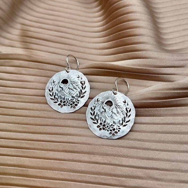 Fluff Hardware Prairie Earrings are handcrafted silver earrings featuring clean, cut-out pendants with a modern, nature-inspired shape. Available in small or large, these lightweight earrings hang from hypoallergenic sterling silver ear wires and are designed for comfortable everyday wear. A versatile small-batch accessory and an easy gift for lovers of minimalist, artisan jewelry.