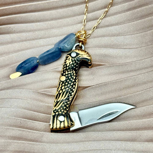 The Talon Necklace by Fluff Hardware is a handcrafted gold-filled necklace featuring an eagle-inspired functional talon utility charm accented with natural kyanite beads. Designed for intentional wear, this mixed-use piece blends symbolic jewelry with practical design. Finished with a hypoallergenic 14k gold filled chain, it’s a bold, meaningful accessory for those drawn to empowered, purpose-driven adornment.