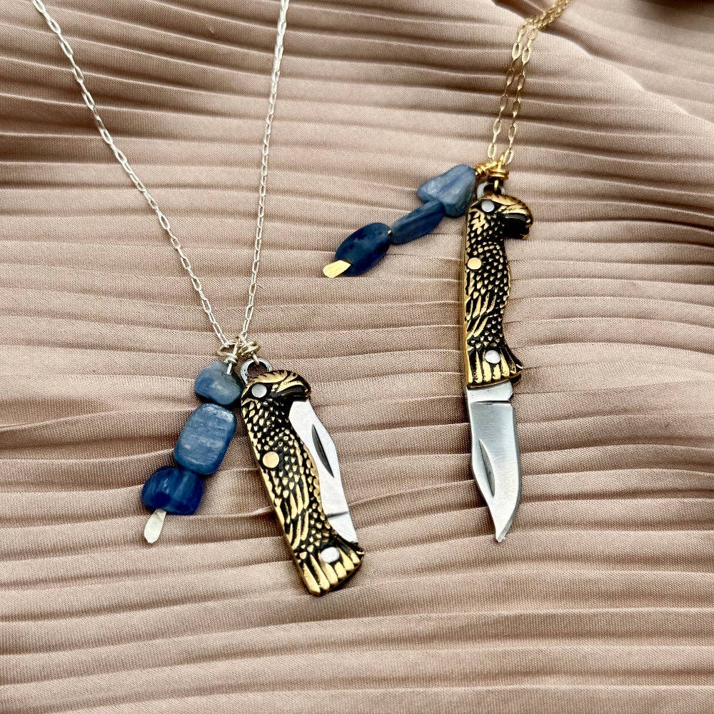 The Talon Necklace by Fluff Hardware is a handcrafted gold-filled necklace featuring an eagle-inspired functional talon utility charm accented with natural kyanite beads. Designed for intentional wear, this mixed-use piece blends symbolic jewelry with practical design. Finished with a hypoallergenic 14k gold filled chain, it’s a bold, meaningful accessory for those drawn to empowered, purpose-driven adornment.