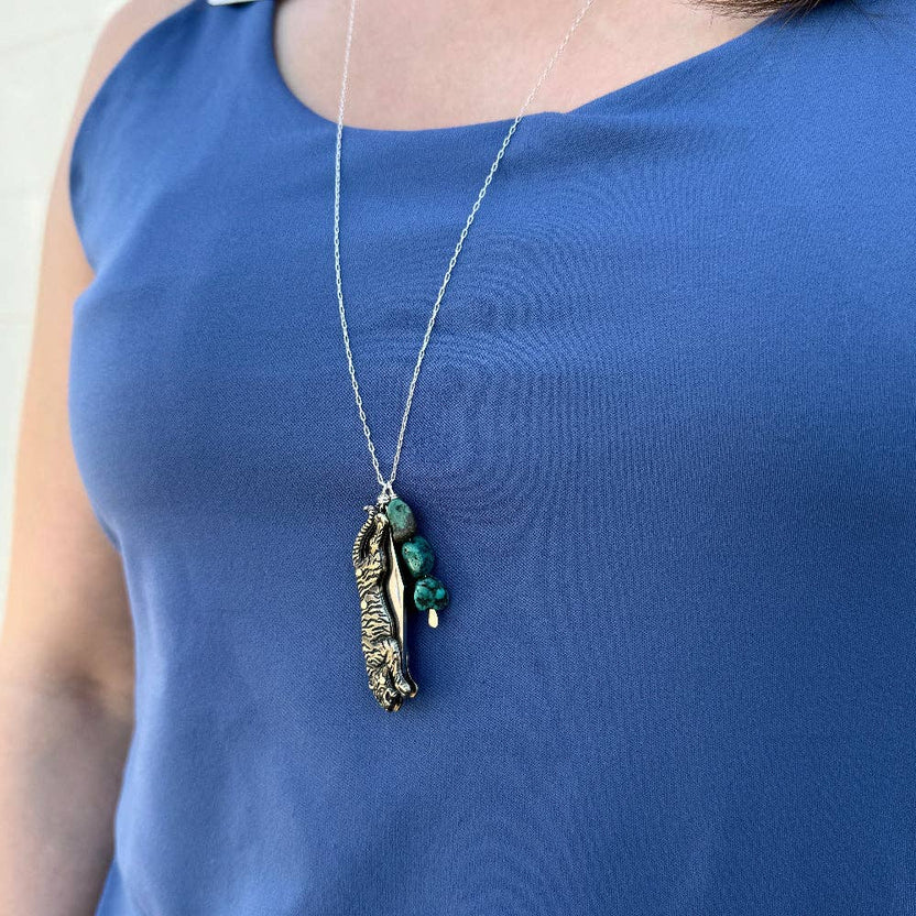 The Untamed Necklace by Fluff Hardware is a handcrafted gold-filled necklace featuring a tiger-inspired functional utility charm accented with natural turquoise nugget beads. Designed for empowered, intentional wear, this small-batch piece blends symbolic jewelry with practical design. Finished on a hypoallergenic 14k gold filled chain, it’s a striking accessory for those drawn to bold craftsmanship and purpose-driven adornment.