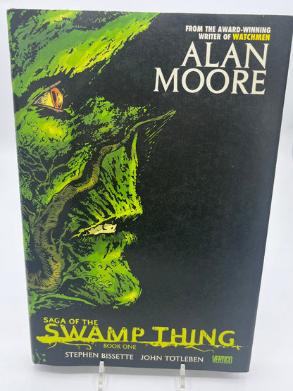 Preowned Like New hardcover edition of Saga of the Swamp Thing, Book One from Vertigo, featuring art by Stephen R. Bissette and John Totleben, with early issues written by Alan Moore. This collectible hardcover is a foundational horror graphic novel, perfect for fans of Vertigo comics, dark fantasy, and influential comic book storytelling.