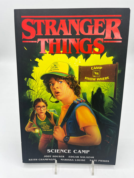 Preowned Very Good copy of Stranger Things: Science Camp, a Stranger Things graphic novel by Jody Houser and team. A fun horror-tinged mystery set in the Stranger Things world, perfect for fans of the series and readers who enjoy spooky adventures, sci-fi weirdness, and collectible tie-in comics.