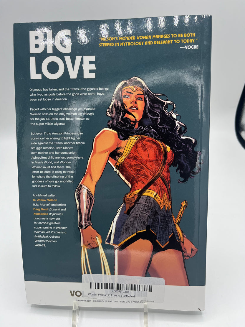 Preowned Excellent copy of Wonder Woman, Vol. 2: Love Is a Battlefield (DC), written by G. Willow Wilson with art by Cary Nord and Xermanico. Collects Wonder Woman #66–73. A strong modern Wonder Woman volume with character-driven storytelling and accessible continuity. Minor cover waviness and a bookstore barcode sticker on the back; otherwise clean and solid—great for reading or completing the run.