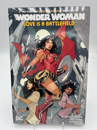Preowned Excellent copy of Wonder Woman, Vol. 2: Love Is a Battlefield (DC), written by G. Willow Wilson with art by Cary Nord and Xermanico. Collects Wonder Woman #66–73. A strong modern Wonder Woman volume with character-driven storytelling and accessible continuity. Minor cover waviness and a bookstore barcode sticker on the back; otherwise clean and solid—great for reading or completing the run.