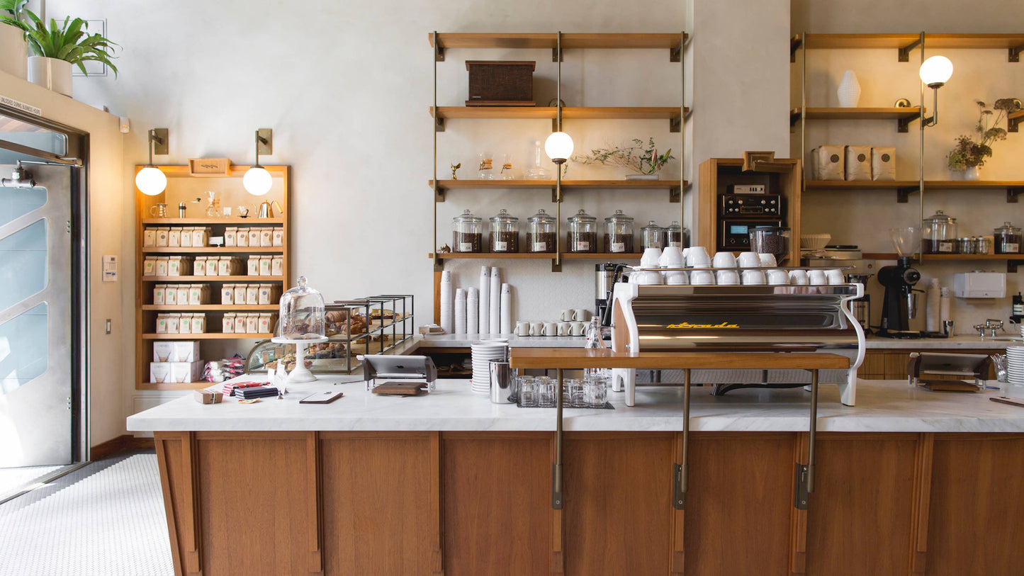 Interior of the Sightglass Coffee café in San Francisco featuring the espresso bar and coffee retail shelves.