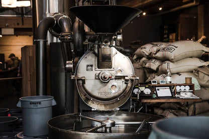 Probat coffee roaster at the Sightglass Coffee roastery with burlap sacks of green coffee beans.