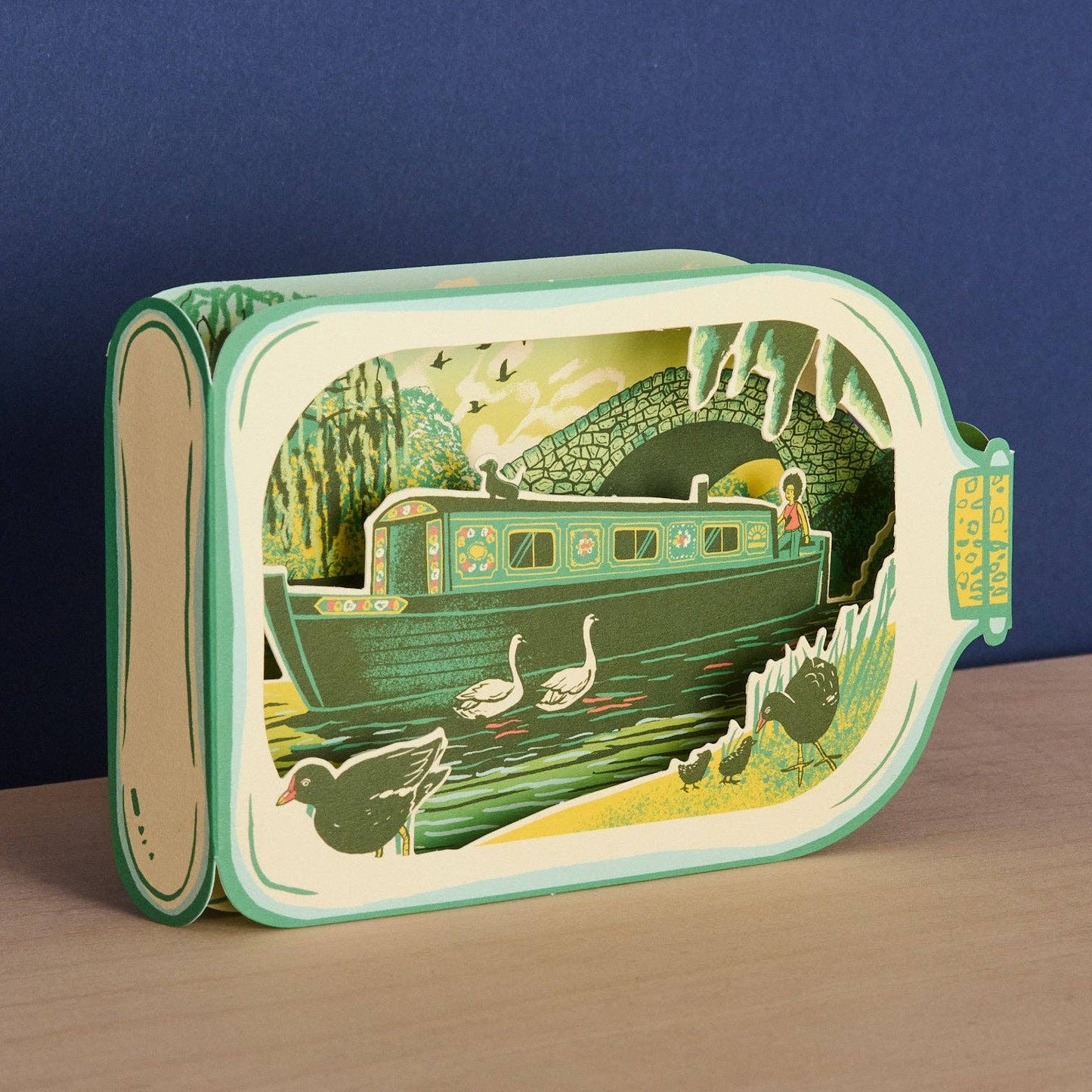 Tom Jay Canal Boat in a Bottle die-cut greeting card featuring a narrowboat, swans, and canal wildlife inside a bottle-shaped design.