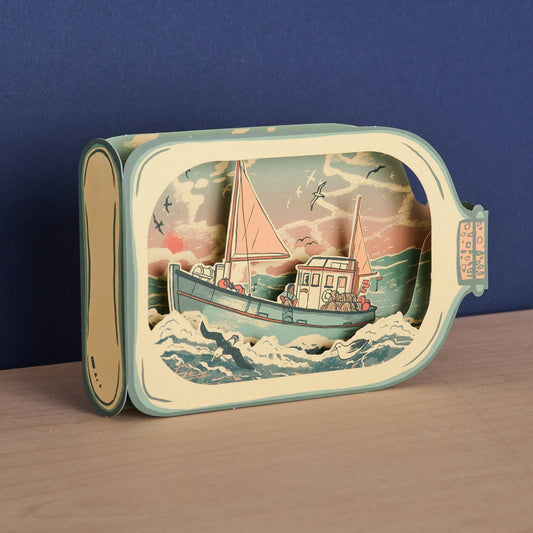 Tom Jay Fishing Boat in a Bottle die-cut greeting card featuring a fishing boat riding rolling waves inside a bottle-shaped design.