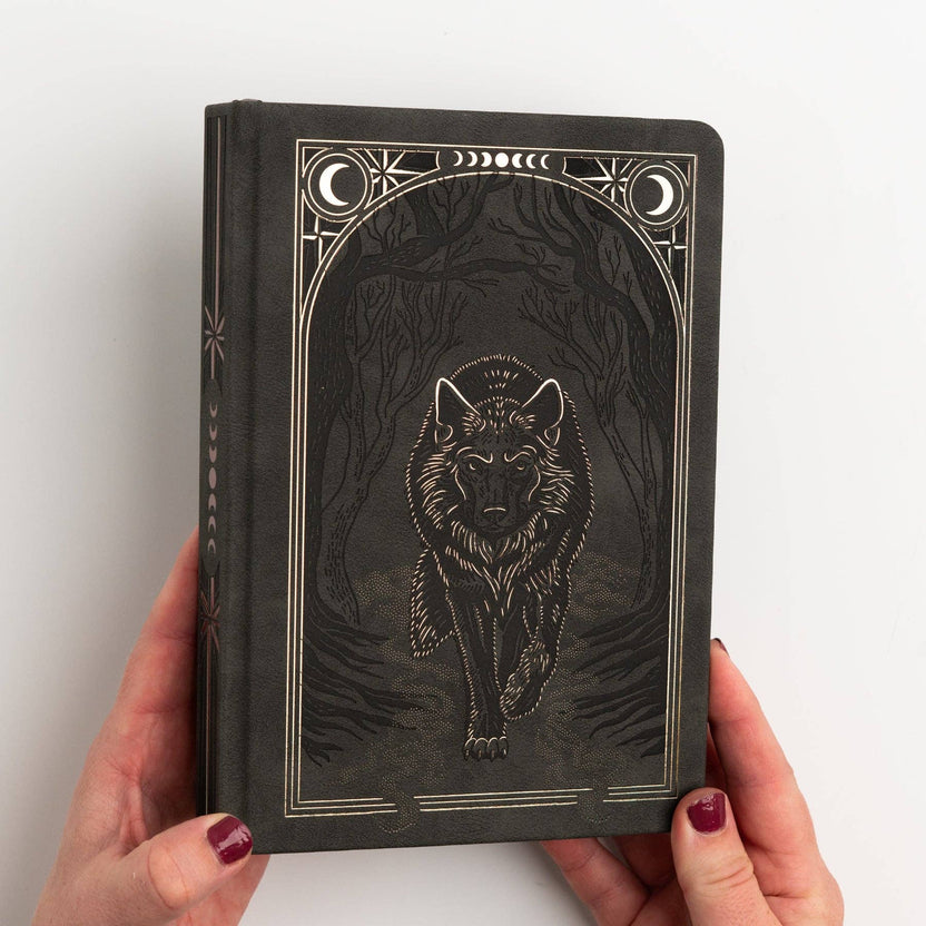 Wolf in the Night B5 notebook held in two hands for scale
