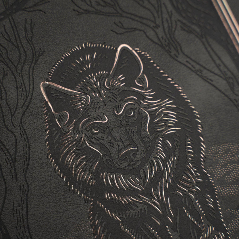 Close-up of embossed wolf and copper foil artwork on Wolf in the Night notebook